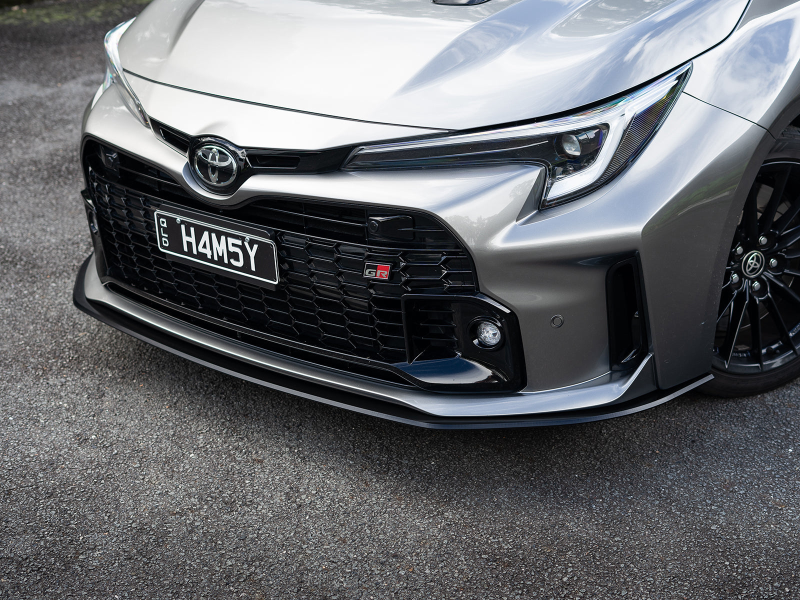 GR Corolla front lip shot from ground level to show depth and clearance.