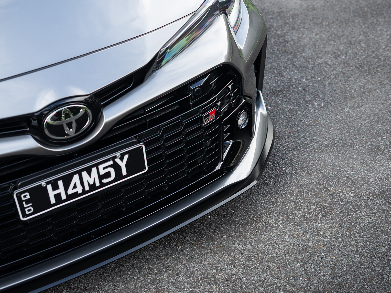 GR Corolla front lip shot from ground level to show depth and clearance.
