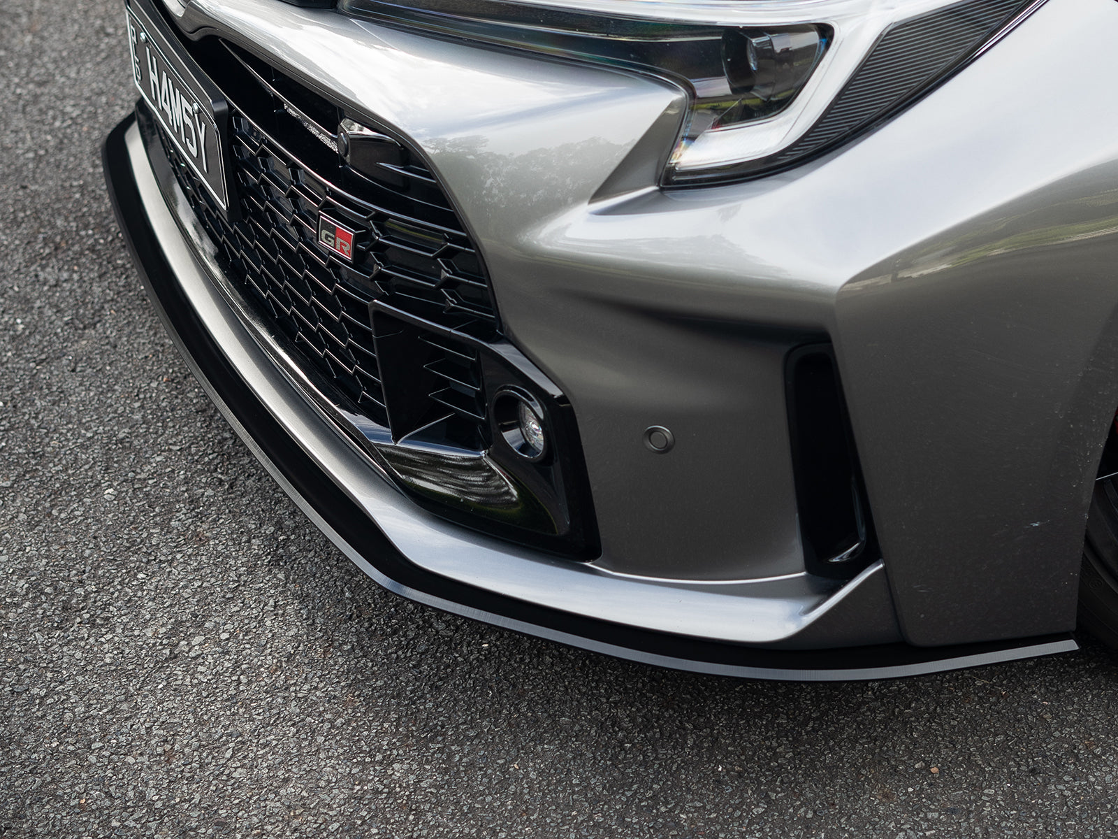 Side profile of GR Corolla showcasing the extended lines of the front lip spoiler.
